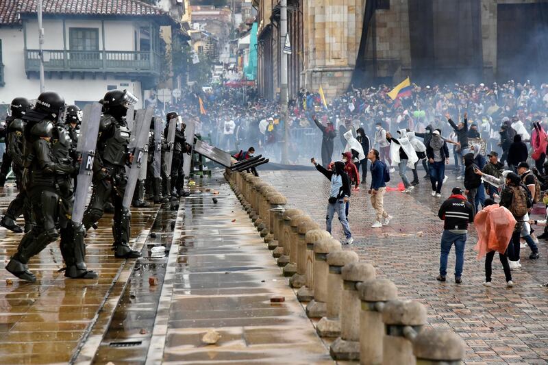 Protesters throw objects and shout at riot police at Bolivar Square, Bogota, Colombia, during the national strike against the tax reform proposed by President Ivan Duque's administration. Getty Images