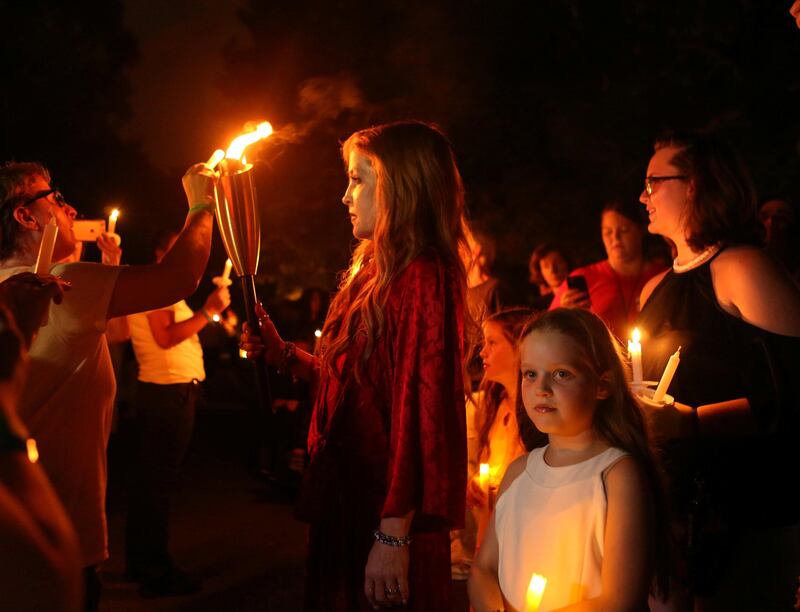 Elvis Presley's daughter Lisa Marie lights the candles of some of the mourners who gathered to commemorate the 40th anniversary of the death of singer Elvis Presley at his former home of Graceland, in Memphis, Tennessee, U.S. August 15, 2017. REUTERS/Karen Pulfer Focht