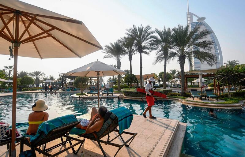 Tourists sunbathe by a pool at Jumeirah Al Naseem hotel in Dubai. Hotels have largely returned to normal operations after being closed. AFP