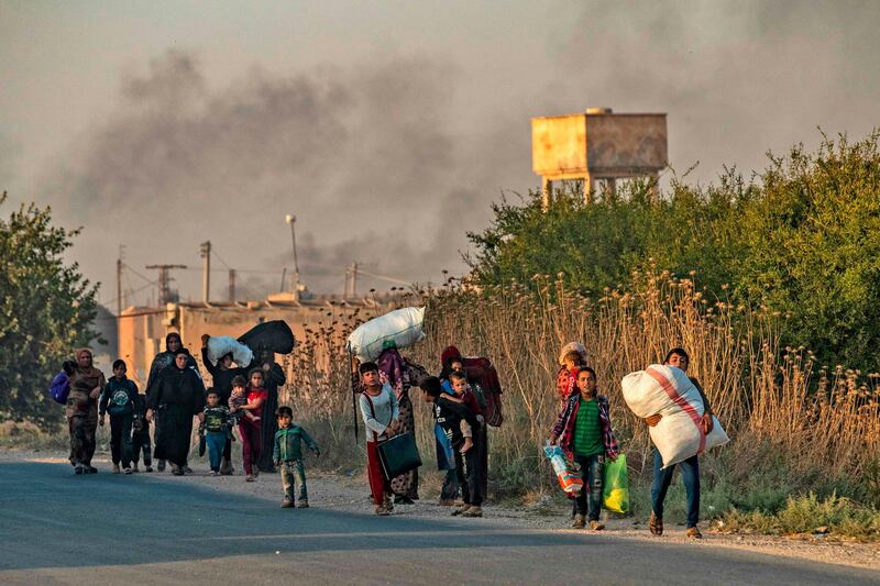 Civilians flee with their belongings amid Turkish bombardment on Syria's northeastern town of Ras Al Ain in the Hasakeh province along the Turkish border. AFP