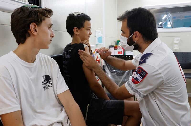 Israeli youths arrive to receive a dose of the Pfizer/BioNTech Covid-19 vaccine - bookings doubled and tripled after Prime Minister Naftali Bennett  warned that currently allotted doses would expire on July 9.