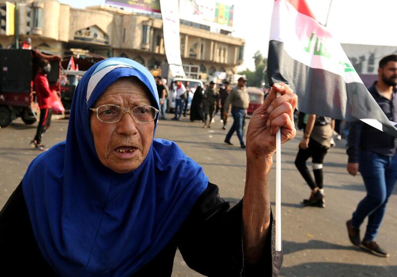An elderly Iraqi woman waves a national flag in the capital Baghdad's Tahrir square during ongoing anti-government demonstrations. AFP