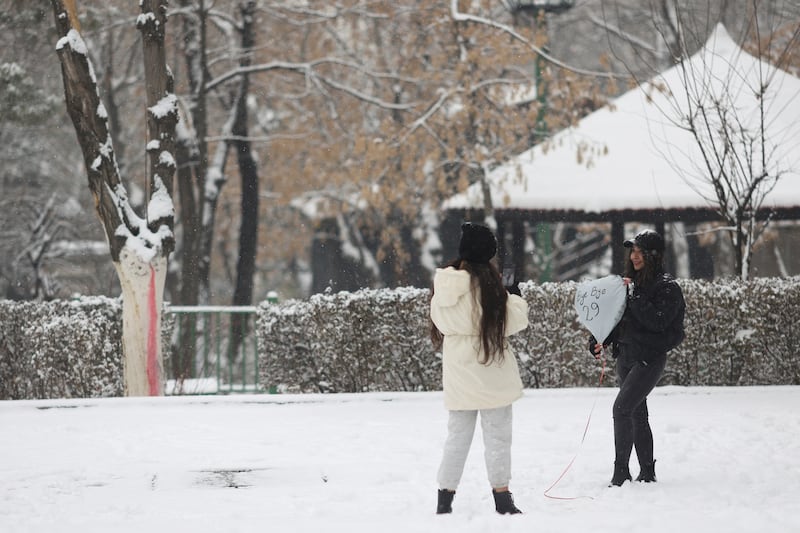 Tehran residents take photos of snowfall in one of the city's parks. Reuters