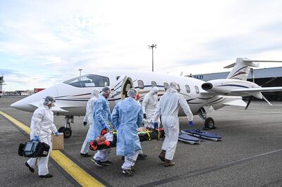 Medical staff take a patient on a gurney to a waiting medical flight at the Bron airport near Lyon, southeastern France, on October 27, 2020, to be evacuated on another hospital, amid the outbreak of the Covid-19 caused by the new Coronavirus. / AFP / PHILIPPE DESMAZES
