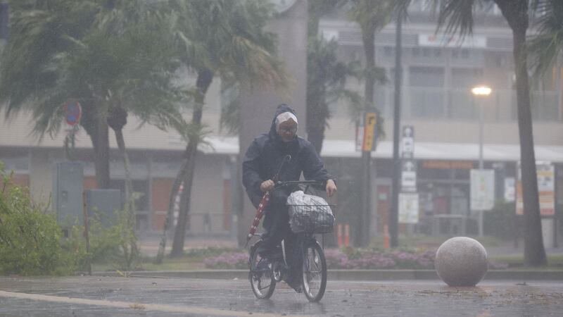 A cyclist braves the rains in Miyazaki. Reuters