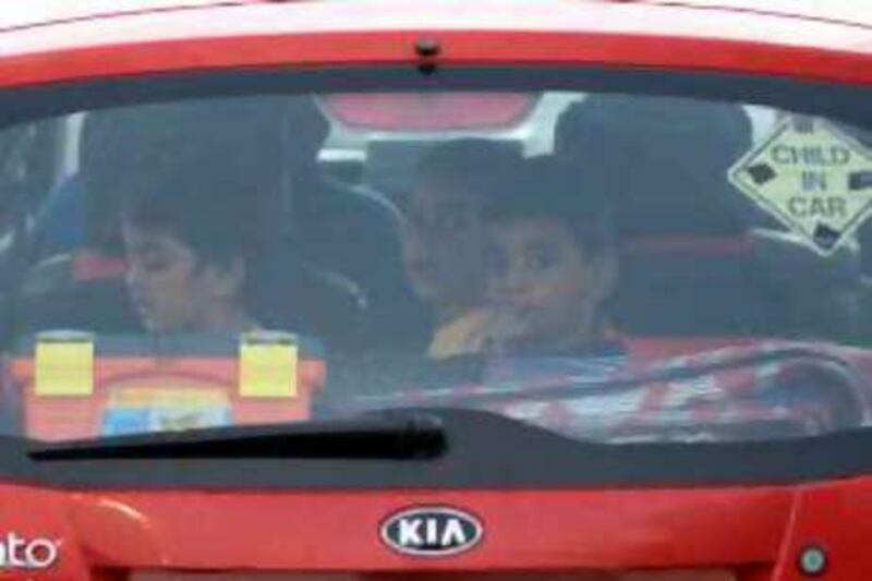 Unbuckled children leave Marina Mall in Abu Dhabi in the back of their parents' car.