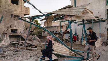 Palestinians survey the damage caused by an Israeli air strike near a UNRWA-run school housing displaced people in the Nuseirat refugee camp in Gaza. EPA