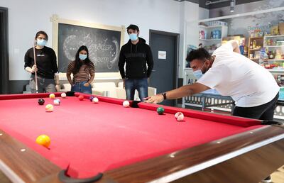 DUBAI, UNITED ARAB EMIRATES , May 7 – 2020 :- Left to Right - Pallavi Verma and Pooja Nambiar students of Heriot-Watt University,  Ali Muzaffar student of Middlesex University and Manny Moid student of Curtin University playing pool in the recreational area at the Uninest Student residences in Dubailand in Dubai. They chose to stay in the student accommodation in Dubai during the COVID 19 pandemic. (Pawan Singh / The National) For News/Online/Instagram. Story by Kelly