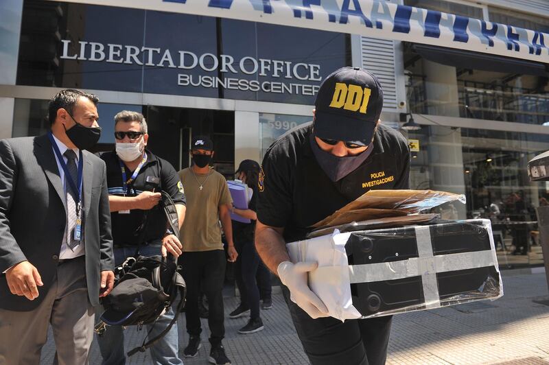 Members of the Argentine Police carry items during a raid at the office of the private physician of Diego Maradona, in Buenos Aires. EPA
