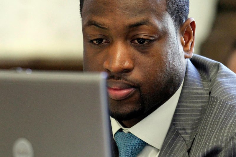 Miami Heat basketball player Dwyane Wade looks on in a Miami court room studying court documents on a computer screen during trial proceedings in a $25 million breach-of-contract lawsuit filed by former partners in a failed restaurant venture, Thursday, May 20, 2010. (AP Photo/J Pat Carter)