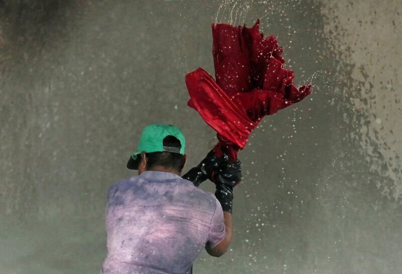 A man washes shirts in a water tank at a laundry in Colombo, Sri Lanka. Reuters