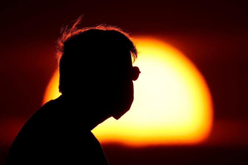 A man watches the sunset from a park in Kansas City. AP Photo