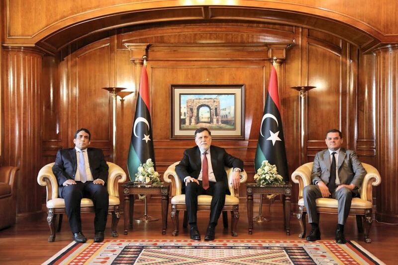 Libya's Prime Minister Abdulhamid Dbeibeh, Libya's internationally recognized former Prime Minister Fayez al-Sarraj, and Mohammed al-Menfi, Head of the Presidency Council, pose for a photo ahead of the handover ceremony in Tripoli, Libya March 16, 2021. The Media Office of the Prime Minister/Handout via REUTERS ATTENTION EDITORS - THIS IMAGE WAS PROVIDED BY A THIRD PARTY.