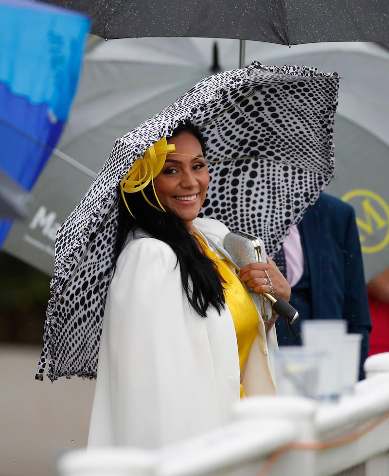 A racegoer poses during the races. Reuters