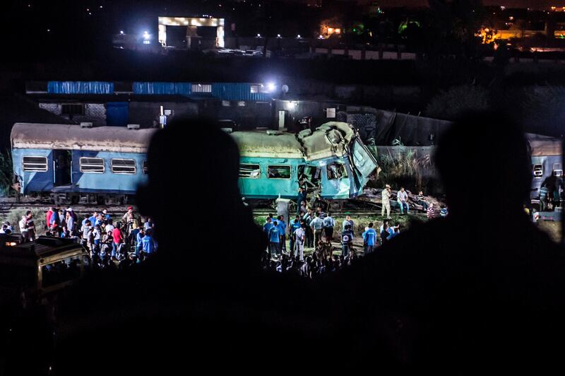 Local people look on as emergency personnel and officials remove the wreckage following a collision by two trains near Khorshid station in Alexandria. 
Khaled Desouki / AFP