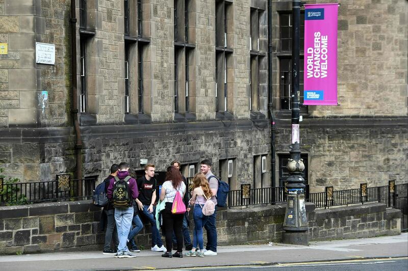 People stand on the pavement to socialise in the West End of Glasgow. AFP