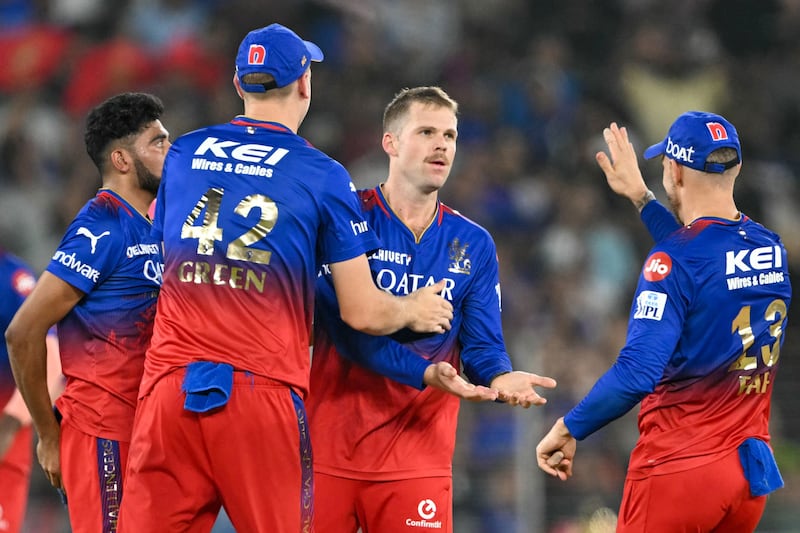 Royal Challengers Bengaluru bowler Lockie Ferguson, second right, celebrates with teammates after taking the wicket of Rajasthan Royals' Tom Kohler-Cadmore. AFP