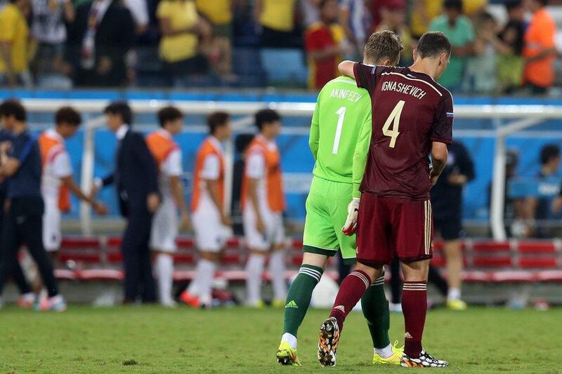 Sergei Ignashevich, right, consoles keeper Igor Akinfeev of Russia after their 1-1 draw with South Korea on Tuesday night at the 2014 World Cup. Akinfeev's mishandling of a long-distance shot allowed South Korea their score. Jose Coelho / EPA / June 17, 2014