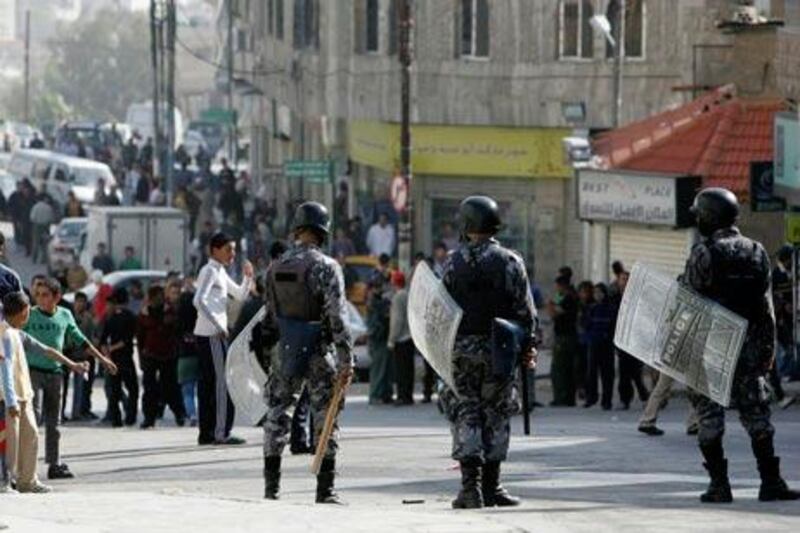 Riot policemen block a road in Amman as protesters demonstrate against the death of a man allegedly caused by police.