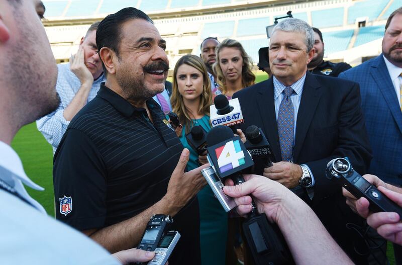 Jacksonville Jaguars owner Shad Khan, left, fields questions from the media on his interest in buying Wembley Stadium in London ahead of the Uniform Launch and Draft Party NFL football event at EverBank Field in Jacksonville, Fla., Thursday, April 26, 2018. The English Football Association has received an offer from Khan of about 600 million pounds ($840 million) for the national soccer stadium, which would continue to host England games and major cup finals after a sale. (Bob Self/The Florida Times-Union via AP)