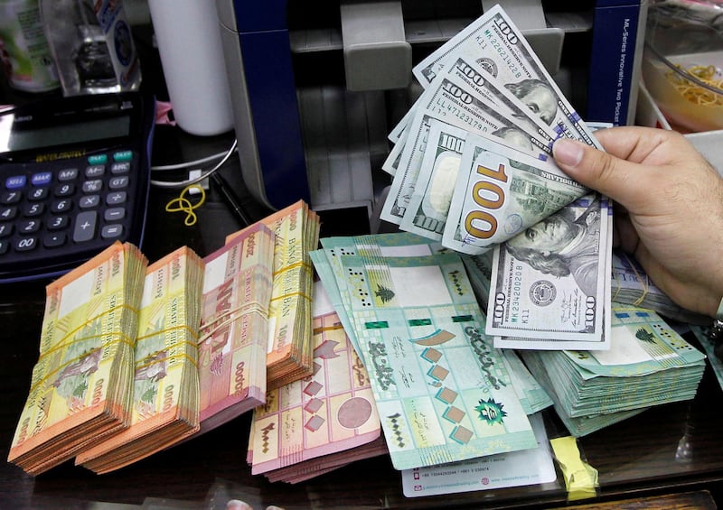 A man counts US dollar banknotes next to Lebanese pounds at a currency exchange shop in Beirut. Reuters, file