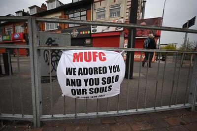 A banner against the proposed European Super League hangs from railings close to Manchester United's Old Trafford stadium in Manchester, northwest England on April 21, 2021.  The proposed European Super League (ESL) appeared dead in the water today after all six English clubs withdrew following a furious backlash from fans and threats from football authorities. / AFP / Oli SCARFF

