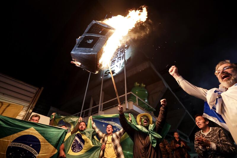 Supporters of Jair Bolsonaro set fire to an electronic voting machine on Avenida Paulista in Sao Paulo. EPA