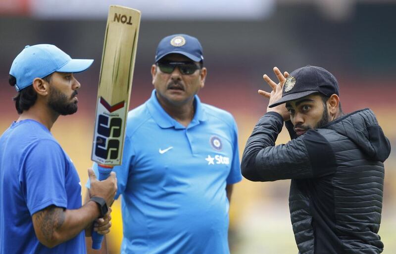 The role of Virat Kohli, right, is more crucial to India's success than that of coach Ravi Shastri, centre. Aijaz Rahi / AP Photo