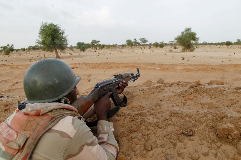 FILE PHOTO: A Niger soldier guards with his weapon pointed towards the border with neighbouring Nigeria, near the town of Diffa, Niger, June 21, 2016. Picture taken June 21, 2016. REUTERS/Luc Gnago/File Photo