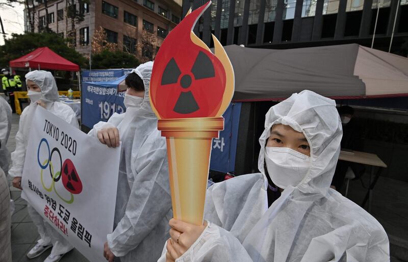 Anti-nuclear activists wearing white protective clothing stage a protest against the Tokyo 2020 Olympic Games. AFP