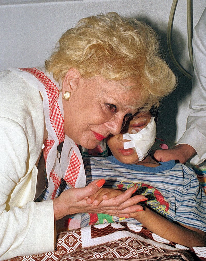 Veteran Egyptian actress Nadia Lutfi kisses the hand of an injured Palestinian child at Nasser hospital in Cairo 8 October 2000. Scores of Palestinians, who were injured during clashes with Israeli soldiers in West Bank, were brought to Egypt for treatment as well as nearby Arab countries. (FILM) (Photo by AMR MAHMOUD / AFP)