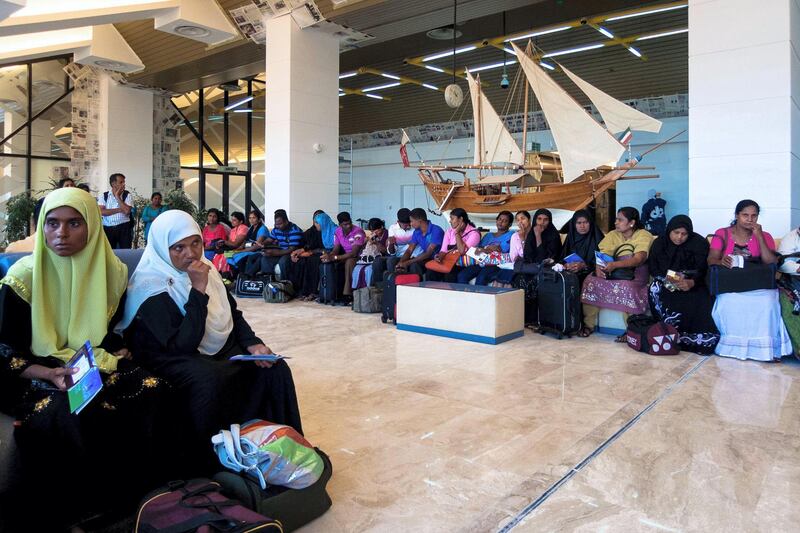 2BN51W1 Kuwait city, Kuwait: group of Indian people in the waiting room of Kuwait city airport waiting to leave for India