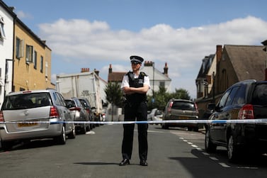 A police officer stands guard in the street where a heavily pregnant woman was stabbed to death in south London. Reuters