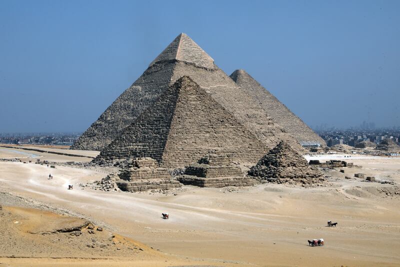 Tourists ride a horse-drawn cart by the pyramids in Giza, Egypt. All photos: EPA