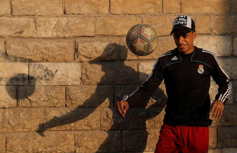 A boy plays football in front of closed Al-Hakim bi-Amr Allah mosque at El Moez Street in old Islamic Cairo. Reuters