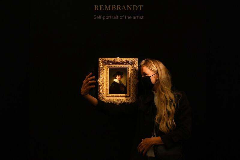 A visitor poses as she takes a selfie with 'Self Portrait' by Dutch master Rembrandt during a media preview for 'Rembrandt to Richter' at Sotheby's auction house in London, Britain.  Reuters