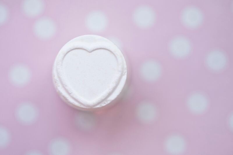 Close-up of a stack of candies with a heart shape on a pink  polka dot background. Getty Images