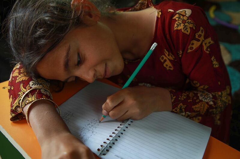 A displaced Syrian girls takes math lessons.