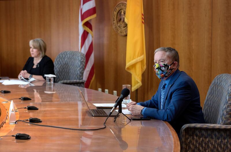 Health and Human Services Secretary Dr. David Scrase gives an update on the COVID-19 outbreak in the state as New Mexico Gov. Michelle Lujan Grisham, left, listens during a news conference in the state Capitol in Santa Fe, N.M..  AP