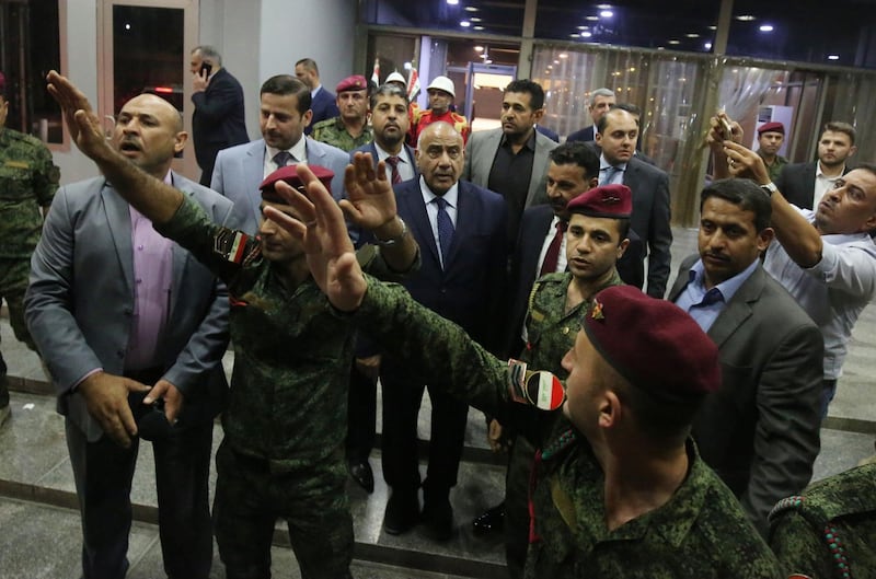 Newly designated Iraqi Prime Minister Adel Abdul Mahdi (C) walks out of the Parliament in Baghdad on October 2, 2018.  / AFP / AHMAD AL-RUBAYE
