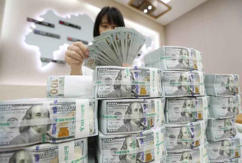 epa06122379 An employee looks at stacks of US dollars at the KEB-Hana Bank in Seoul, South Korea, 03 August 2017. According to media reports, the Bank of Korea announced that South Korea's foreign exchanges recorded 383.76 billion US dollar as of the end of July 2017, a record high for three months in a row.  EPA/YONHAP SOUTH KOREA OUT