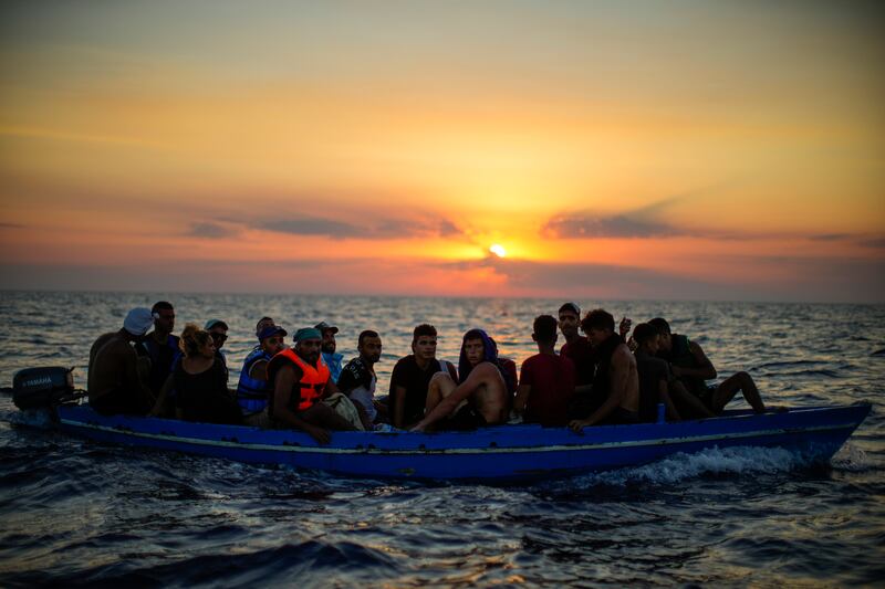 Migrants from Tunisia wait in a wooden boat before they are assisted by crew members of the Spanish NGO Open Arms, in the Mediterranean sea. AP 