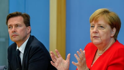 German Chancellor Angela Merkel sits next to German government spokesman Steffen Seibert as she speaks during her summer press conference in Berlin, on July 19, 2019. (Photo by John MACDOUGALL / AFP)