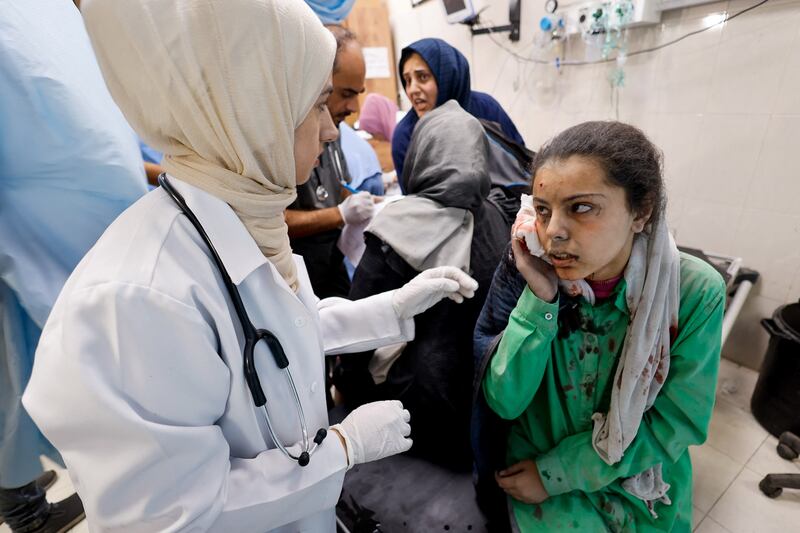 A wounded Palestinian woman following an Israeli strike, receives medical treatment at a hospital in Khan Younis. Reuters