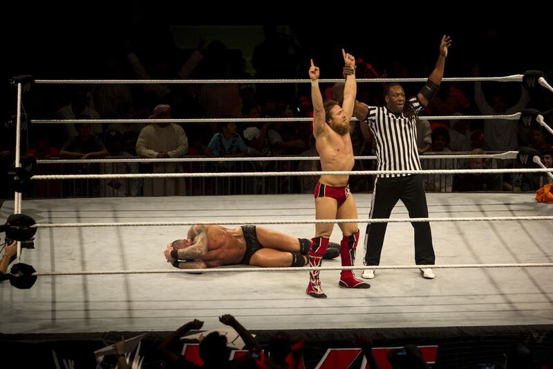Daniel Bryan, centre, celebrates his victory over Randy Orton with Special Guest Referee Booker T during the WWE event at Zayed Sports City in Abu Dhabi on October 10, 2013. Christopher Pike / The National