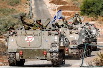 Israeli army tracked medical vehicles move along a road near the northern town of Kiryat Shmona close to the border with Lebanon on October 31, 2023. AFP