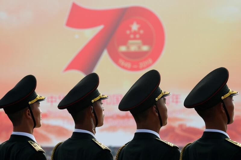Soldiers of People's Liberation Army are seen in front of a sign marking the 70th founding anniversary. Reuters