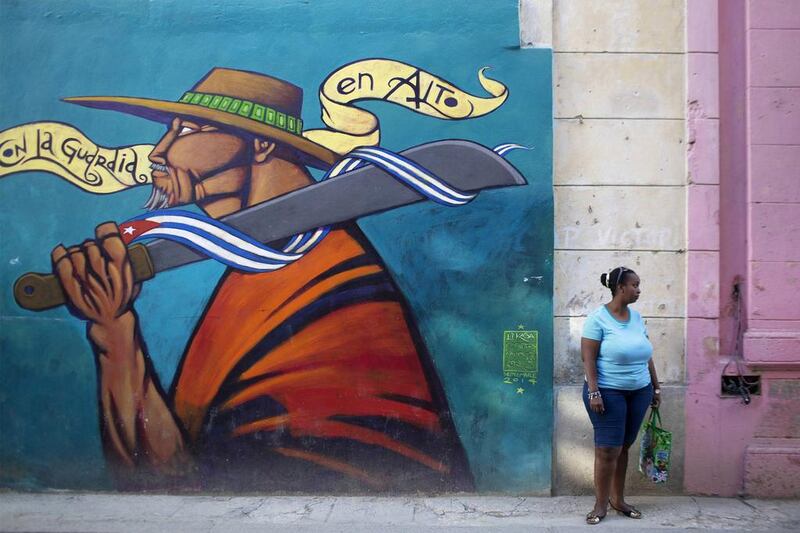 A woman stands on the street in downtown Havana. Many Cubans are already imagining a more prosperous future after the US said it will put an end to 50 years of conflict with the communist-run island. Alexandre Meneghini / Reuters