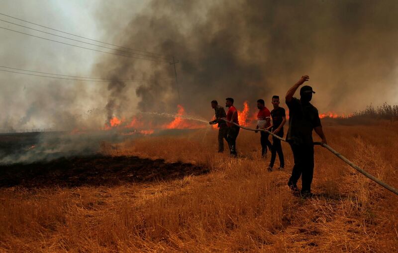 Farmers and residents attempt to put out a fire. Reuters