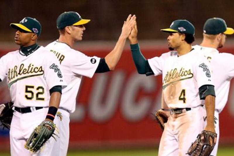 Grant Balfour and Coco Crisp celebrate after Oakland defeat Detroit in game three of their playoff series